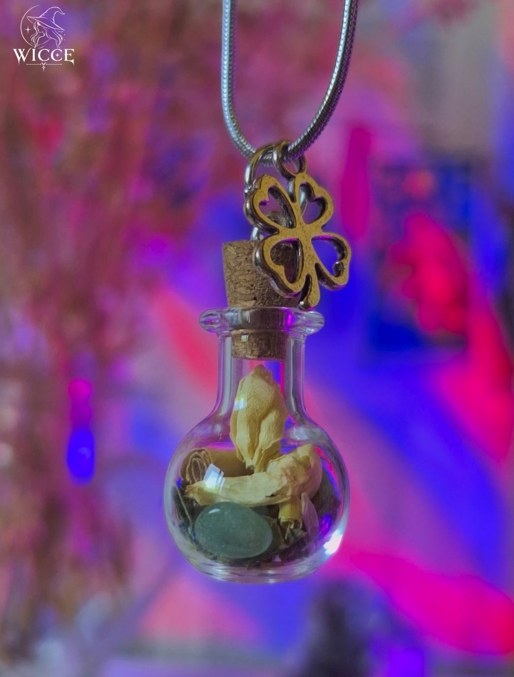 Good Luck talisman necklace with a four-leaf clover charm, glass vial filled with herbs, flowers and a green aventurine.