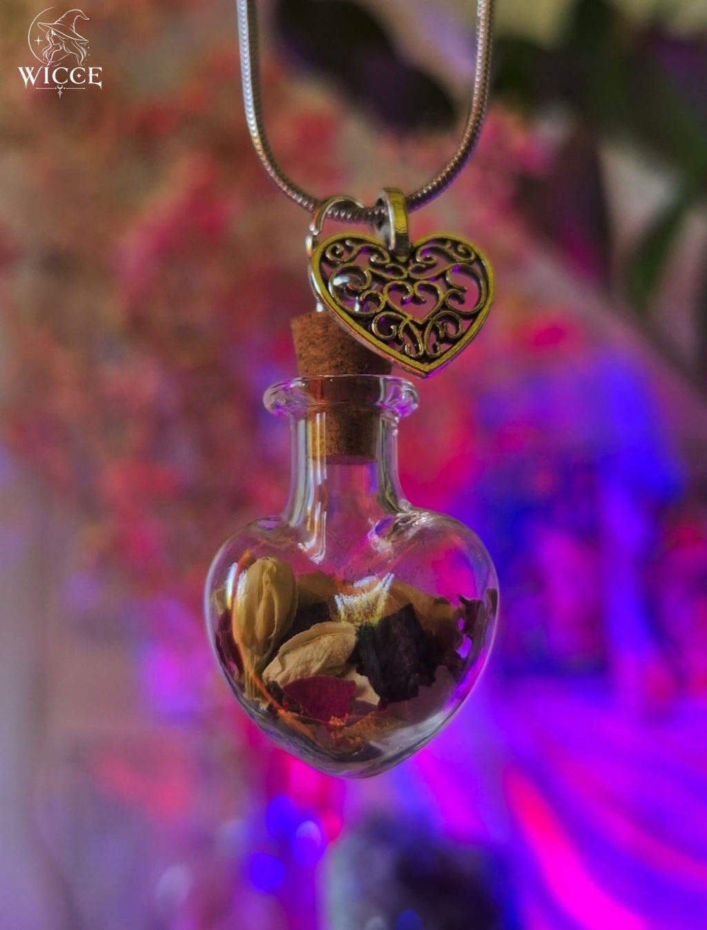 Love talisman necklace with a heart charm, glass vial filled with rose petals, jasmine and herbs.
