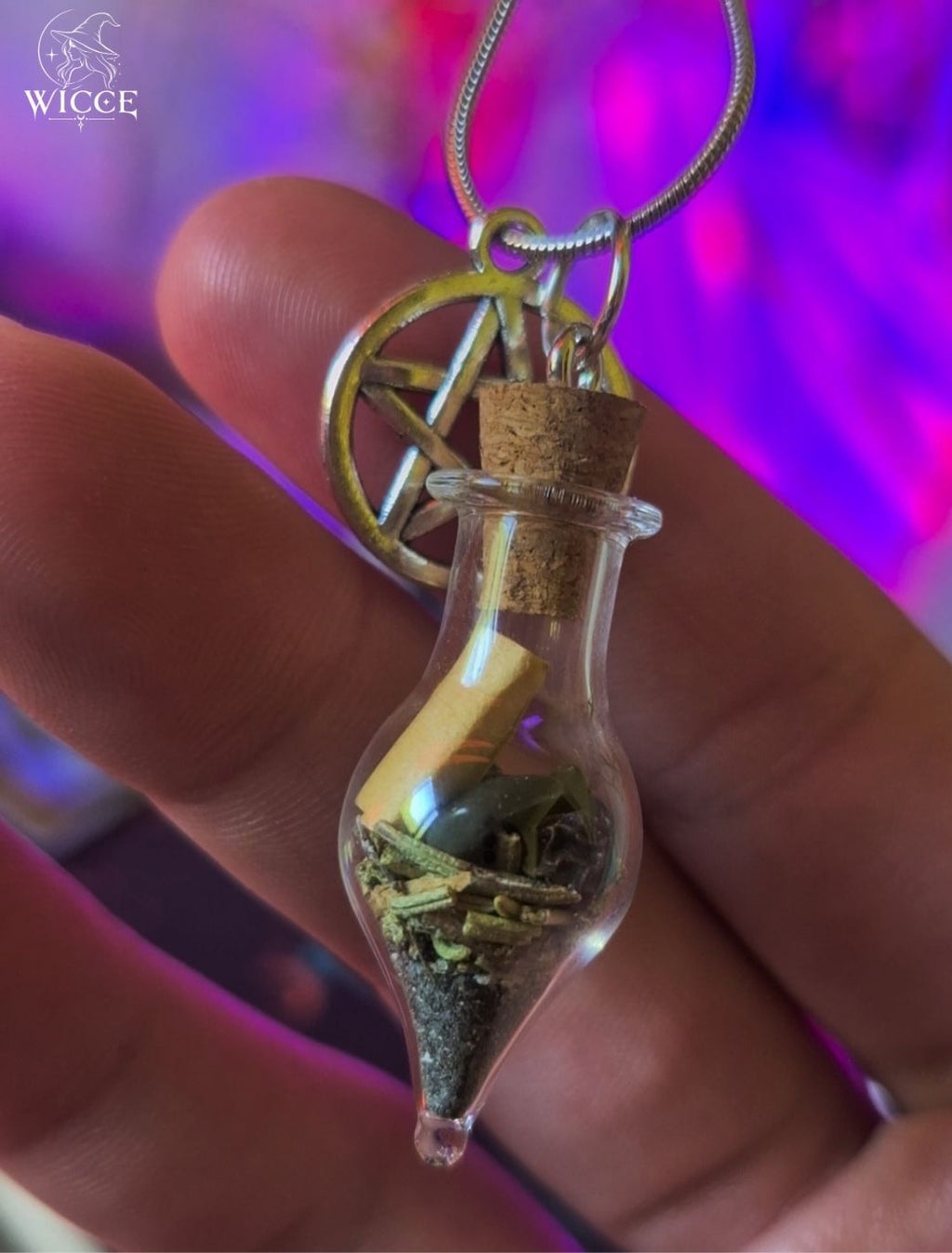 Protection talisman necklace with pentagram charm, glass vial filled with black opsidian, rosemary, black salt and protective herbs held by hand.